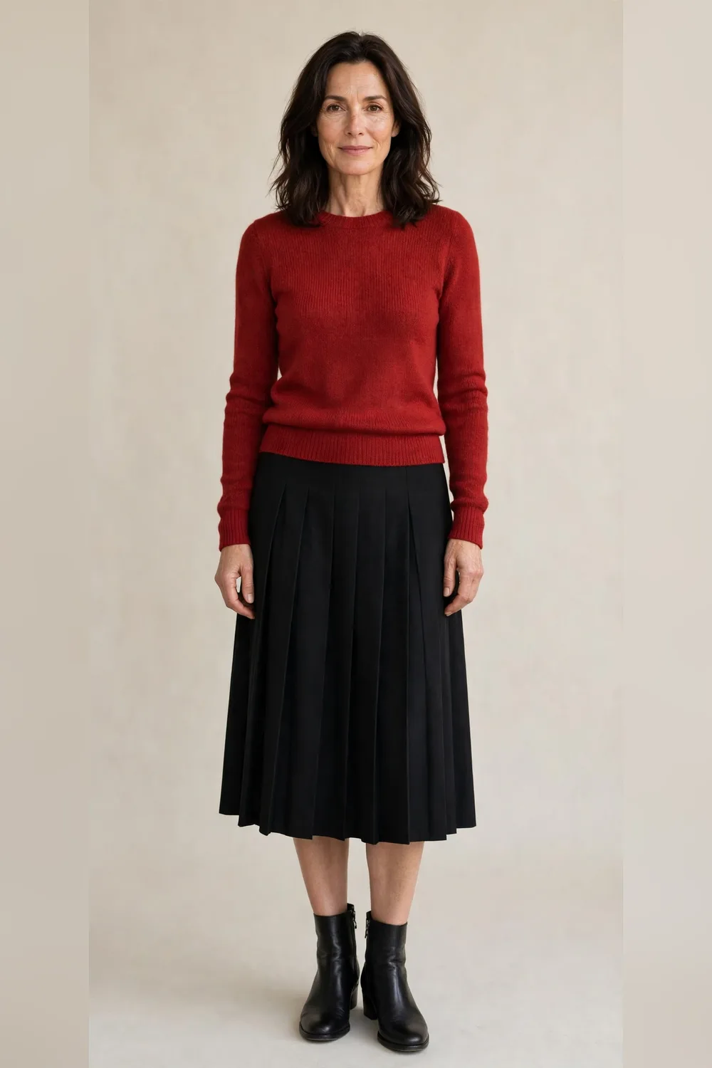 Black pleated midi skirt with a red sweater and ankle boots for Christmas dinner