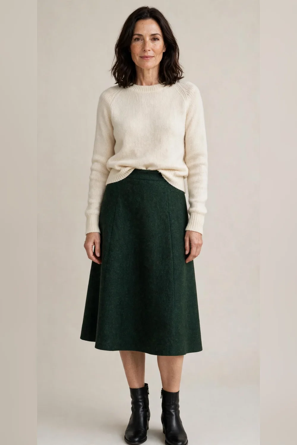 Dark green wool A-line skirt with a cream sweater and boots for Christmas dinner