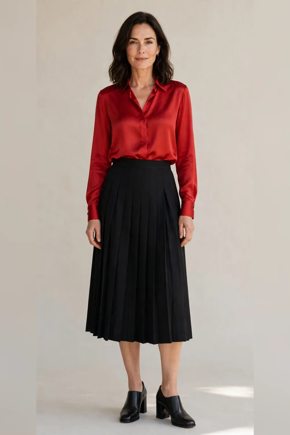 Black pleated midi skirt with a red silk blouse for an office Christmas party
