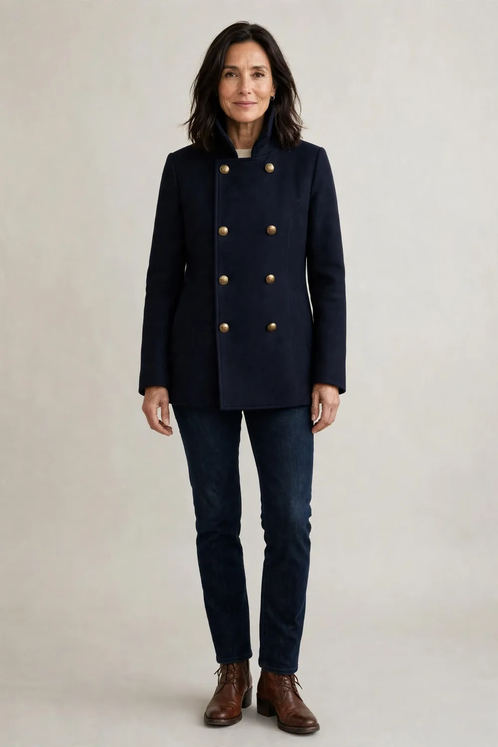 Navy peacoat over a cream sweater with dark jeans and brown boots