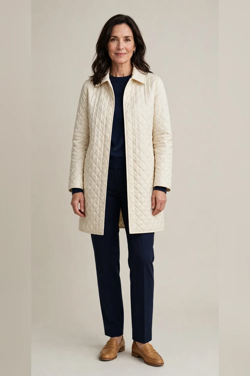 Cream quilted coat with navy straight trousers and tan loafers