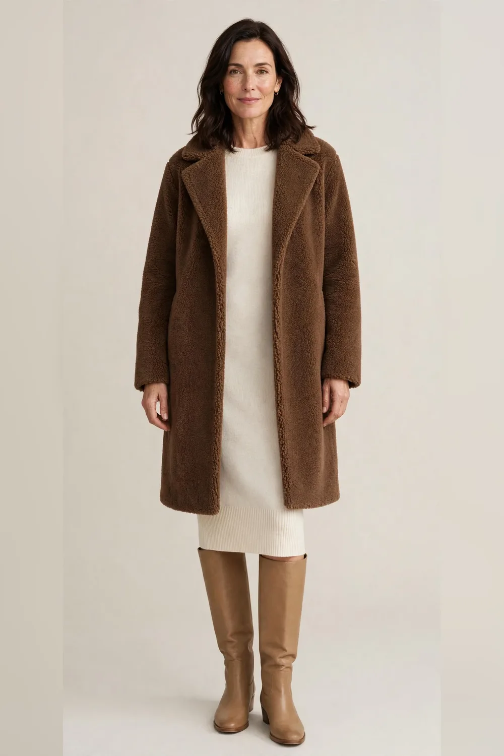 Brown teddy coat over a cream knit dress with tan boots