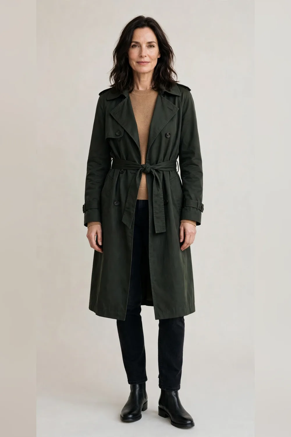 Belted trench coat over a camel sweater with dark jeans and boots
