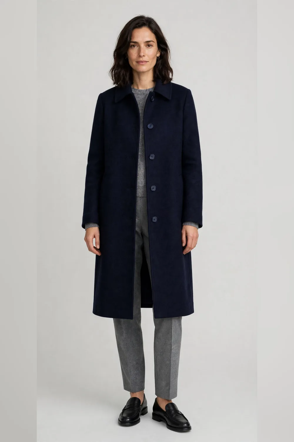 Navy wool coat with grey wool trousers and black loafers for women in their 30s